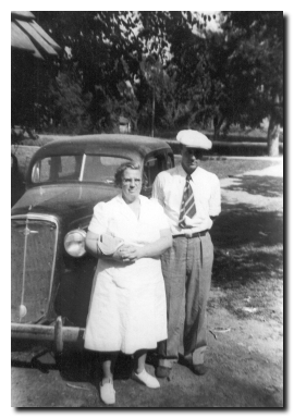 Tom and Beulah Bevins beside the family car